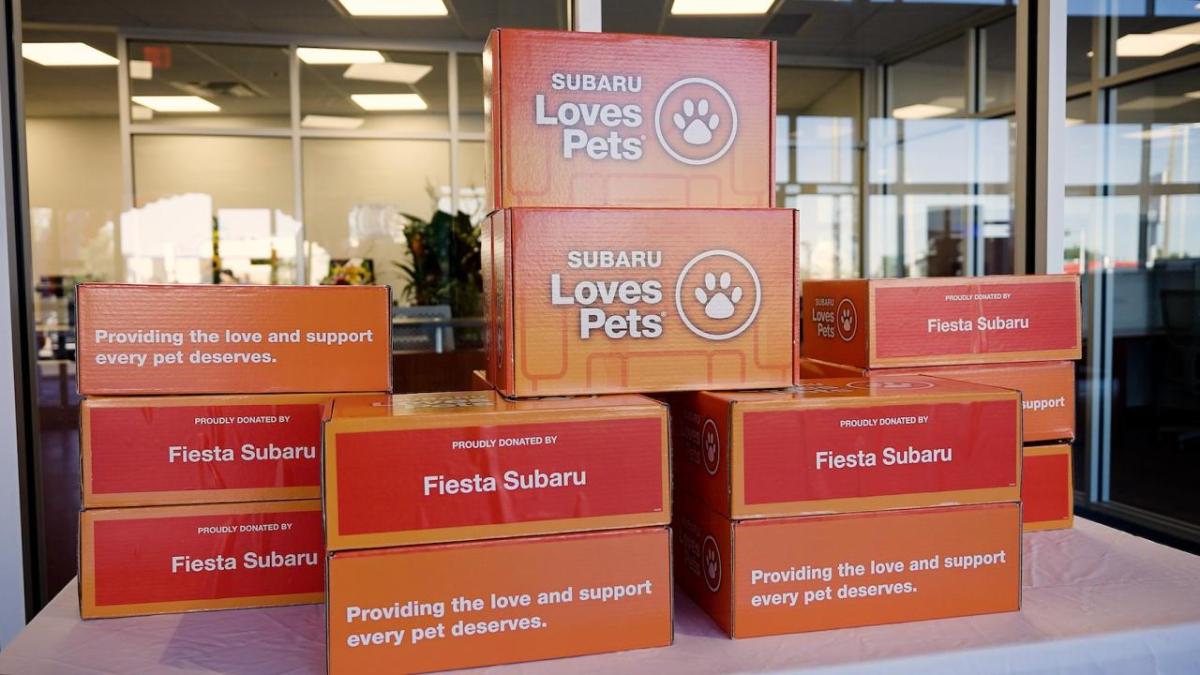 a stack of orange boxes that say "Subaru Loves Pets"