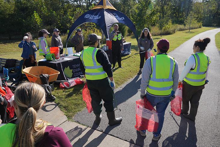 People wearing hi-vis vets near an event stand