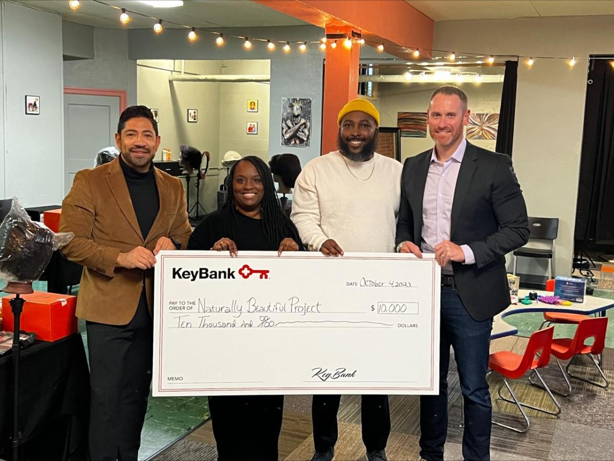 4 people holding a KeyBank Check