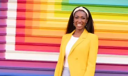 Aisha Bowe stood in front of a multi coloured background