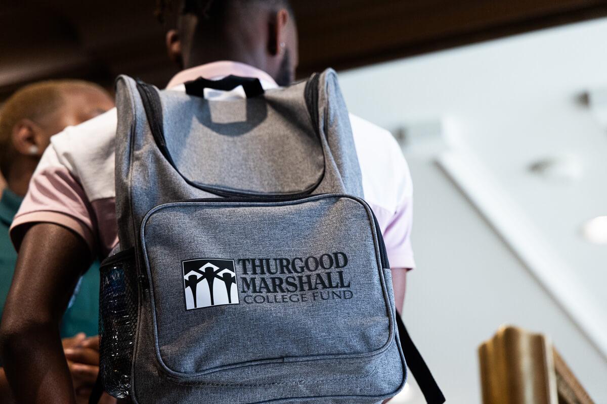 student wearing a gray thurgood marshall college fund backpack