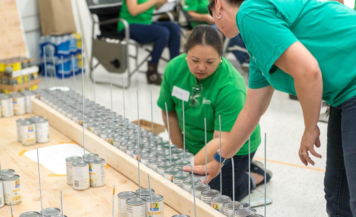 SCE volunteers used metal rods with nuts and bolts to tighten each layer of plywood for their Canstruction electric bucket truck.