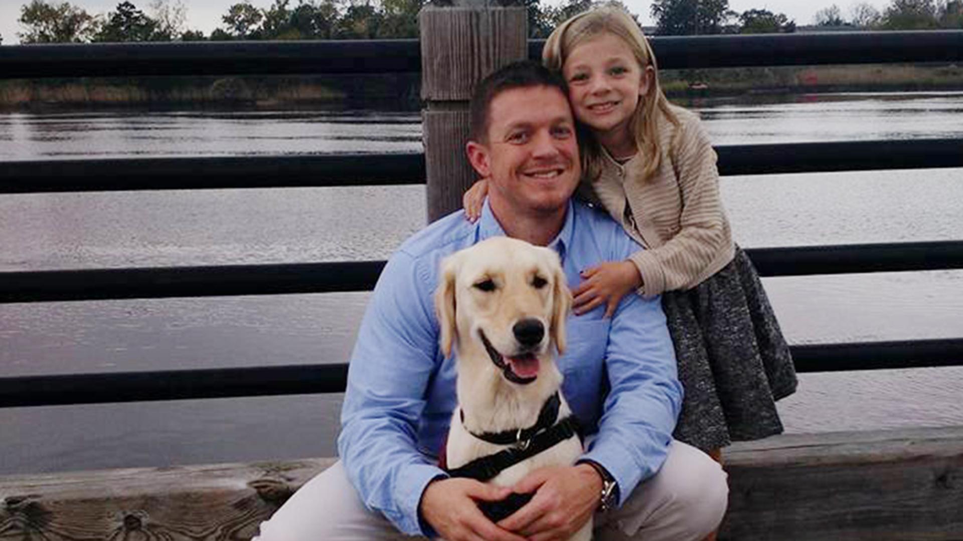 U.S. war veteran, SSG, Jeremy Fouts shares a special bond with his assistance dog EMMA*, who helps mitigate his PTS symptoms. The paws4vets program matches assistance dogs with wounded veterans, active-duty service members and their families. Pictured here are Fout’s, his daughter and EMMA. *paws4people foundation refers to EMMA and all of their assistance dogs using capital letters.