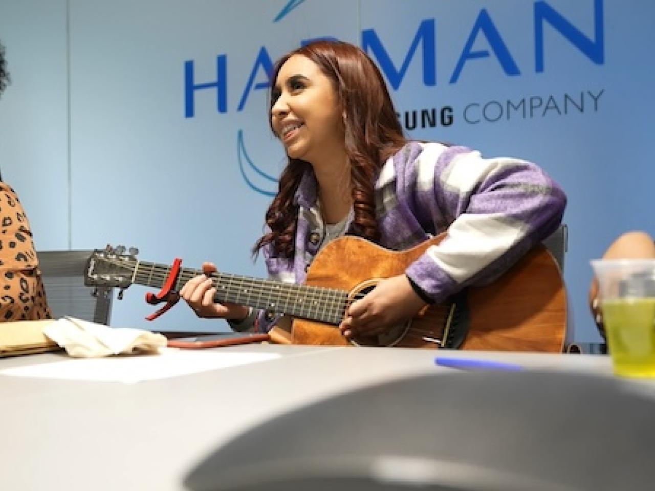 HARMAN Will: Young girl playing an acoustic guitar.