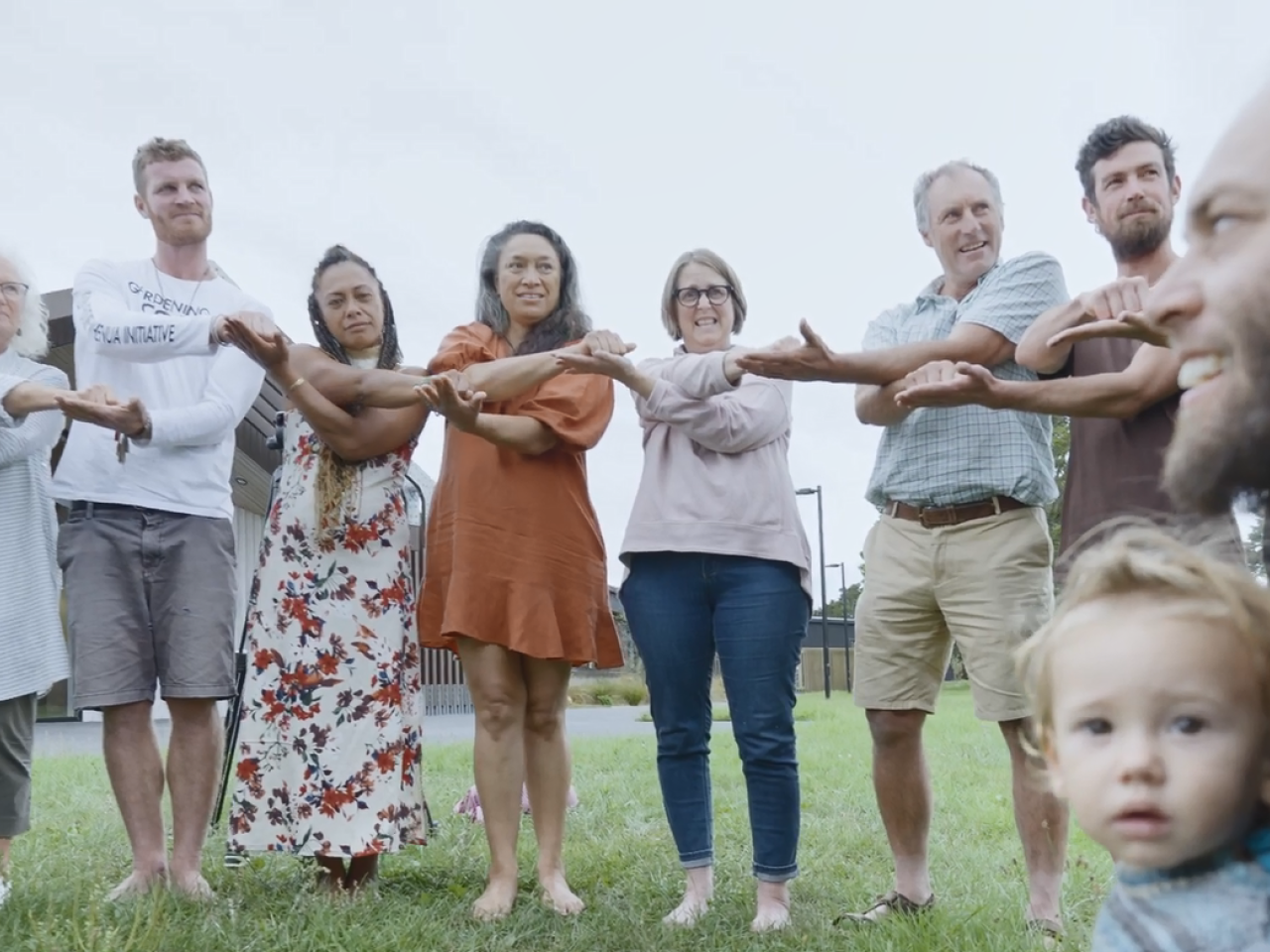 A group of people with interconnected arms standing outside