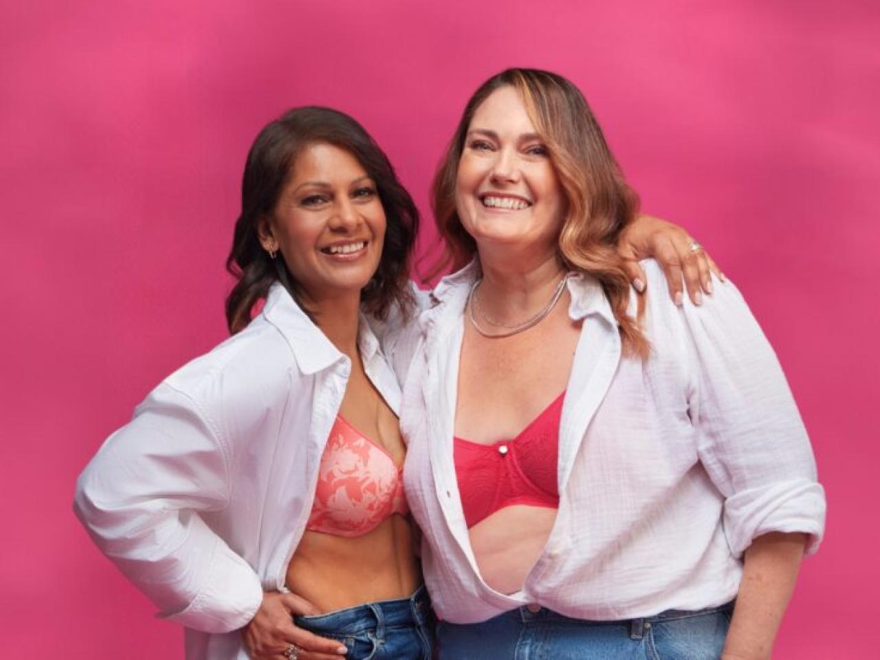 2 people smiling and showing their bras