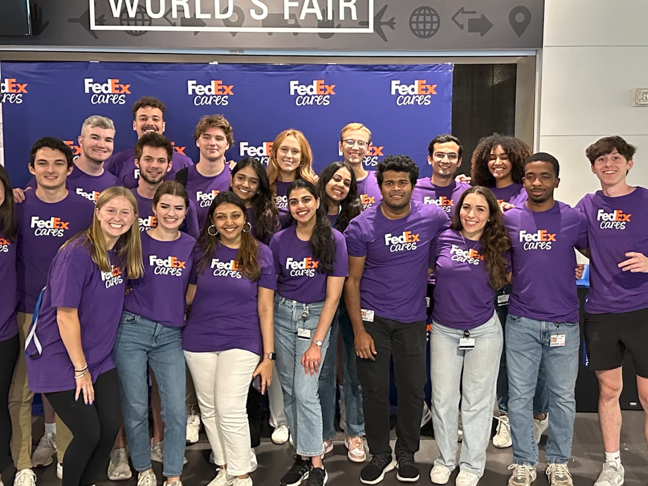 A large group photo of interns wearing purple FedEx Cares t-shirts
