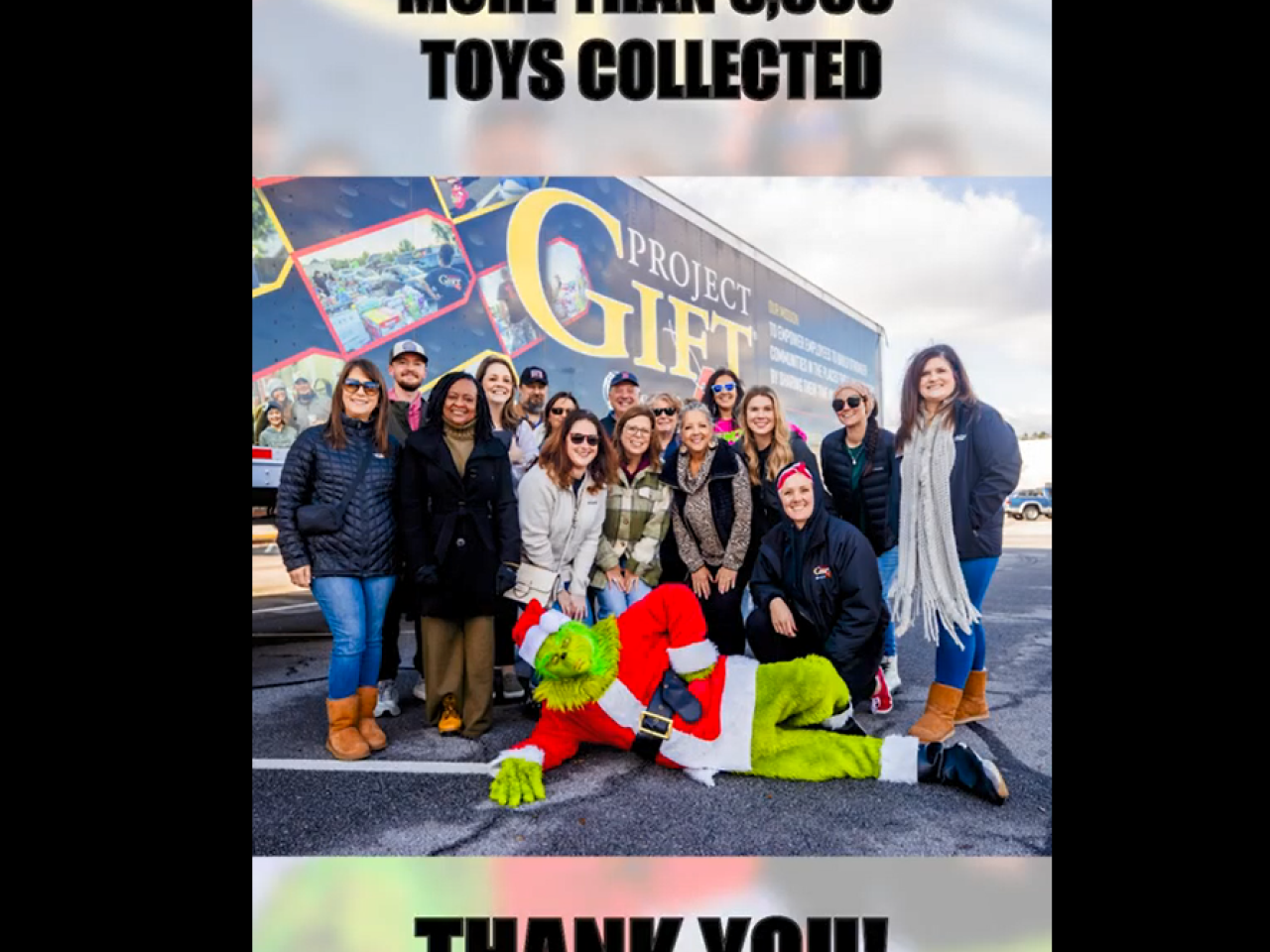 A group posed in front of a semi truck. A person dressed as the Grinch laid out in front of them. "Over 5000 toys collected, Thank you!"