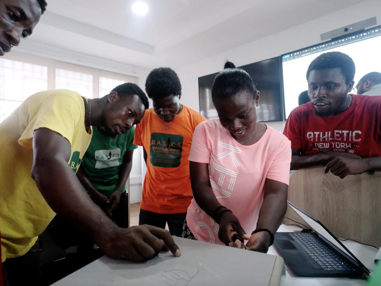 Several people grouped around computer together