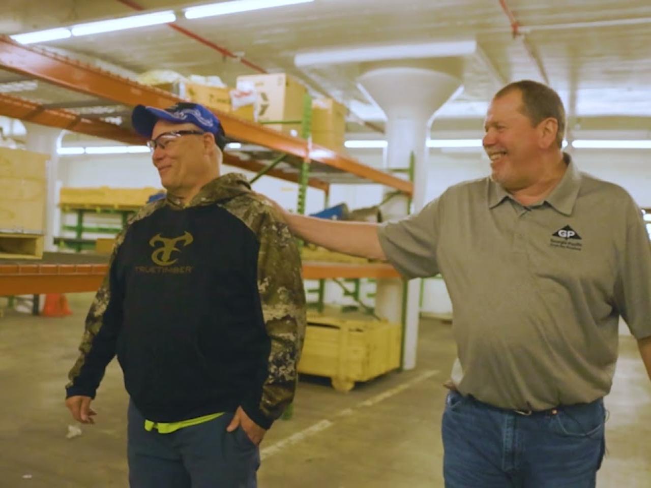 Two employees walking together in a warehouse