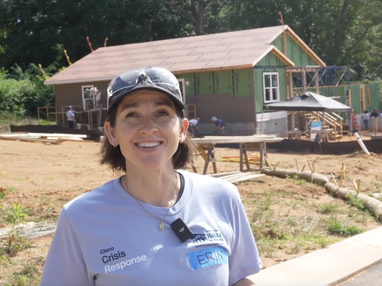 Person speaking in front of house being rebuilt