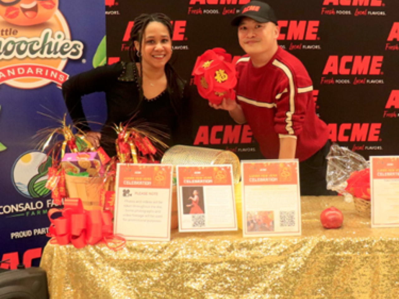 People posing at booth with "ACME" logo