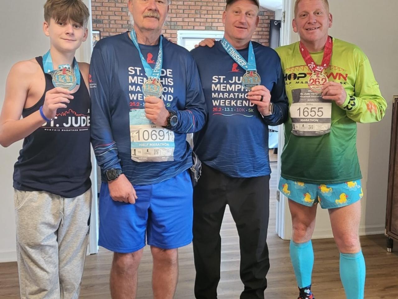 Four people posing together with medals around their necks