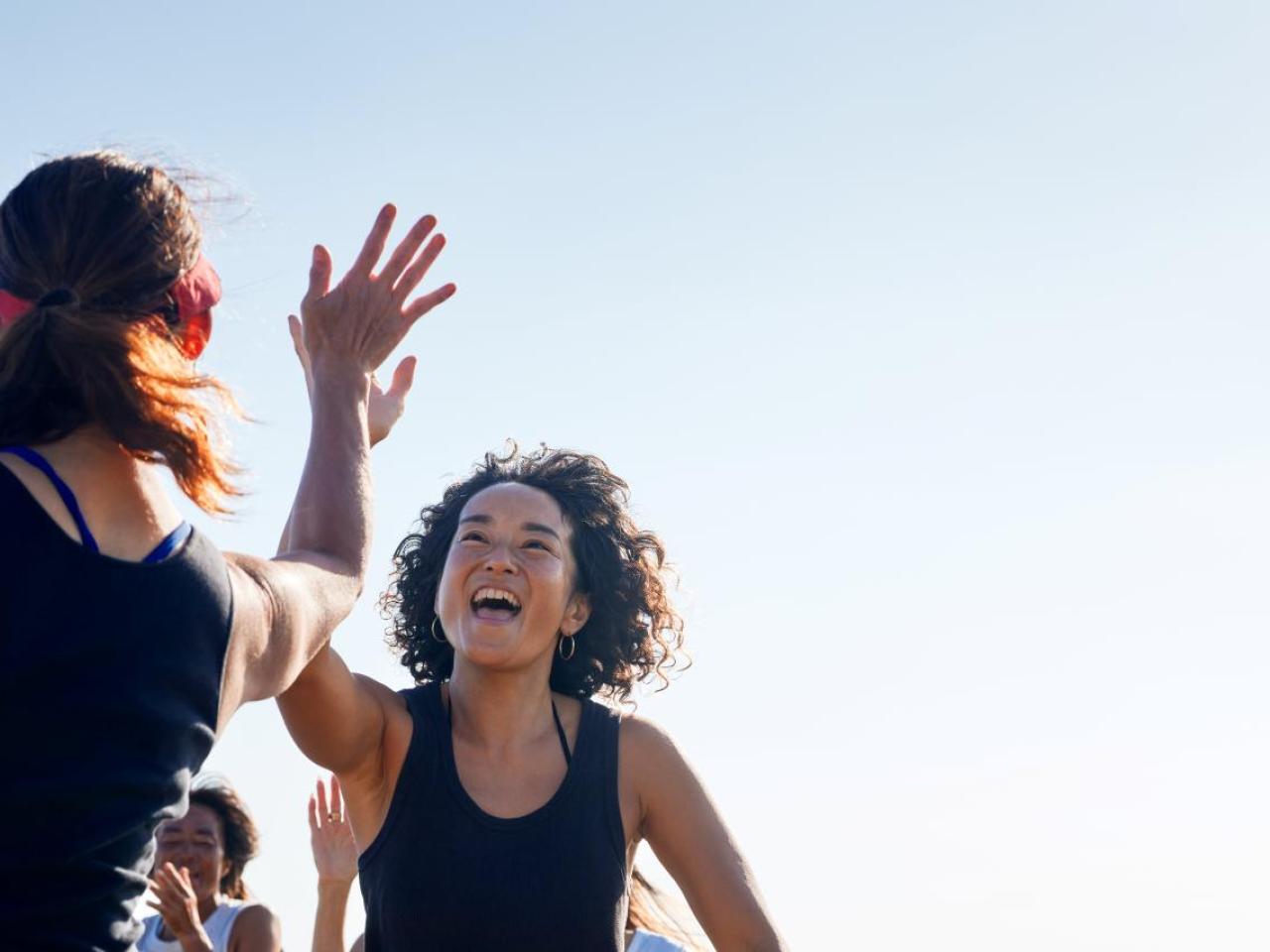 Two people high-fiving outside