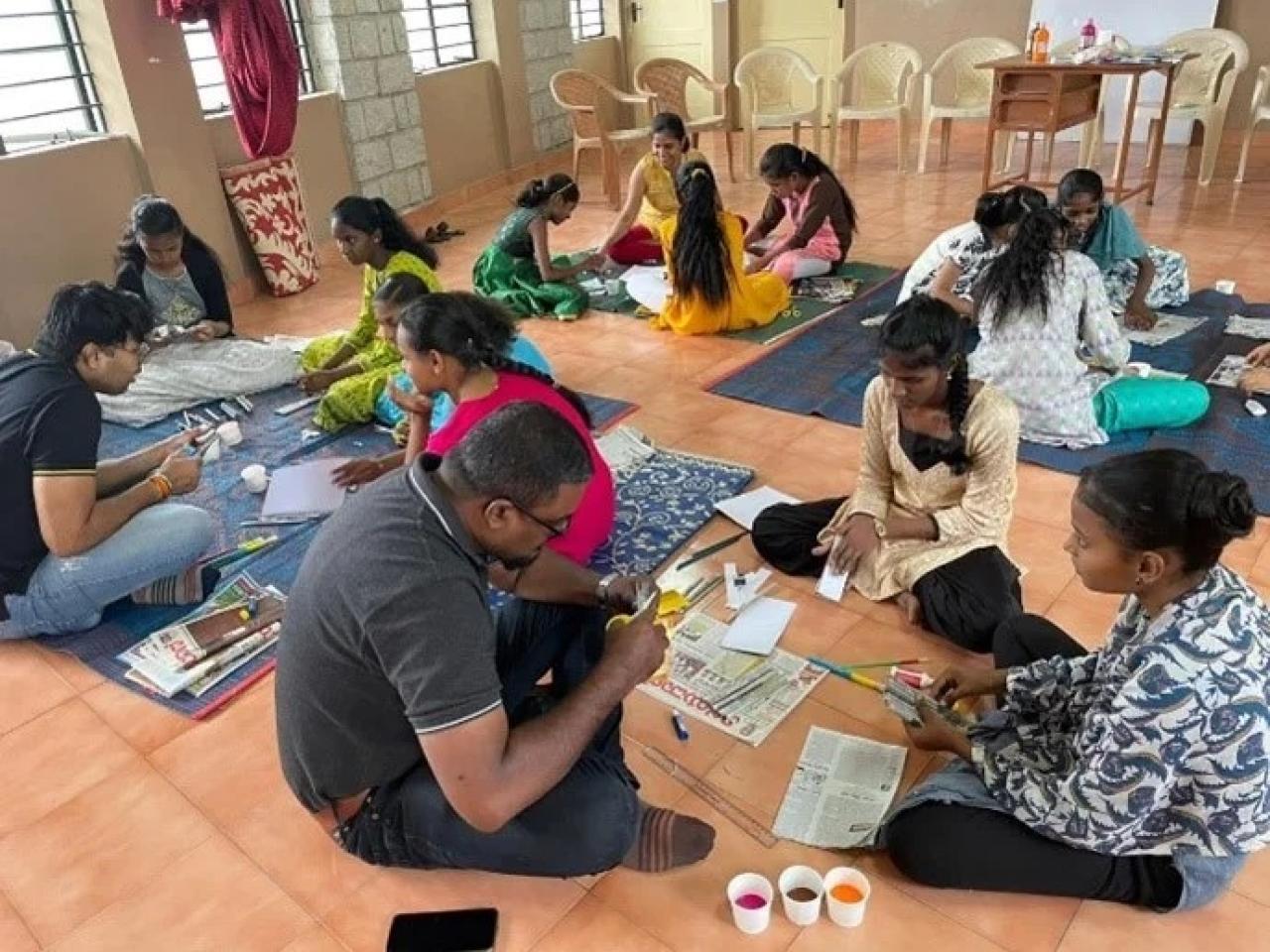 People sat on the floor painting 