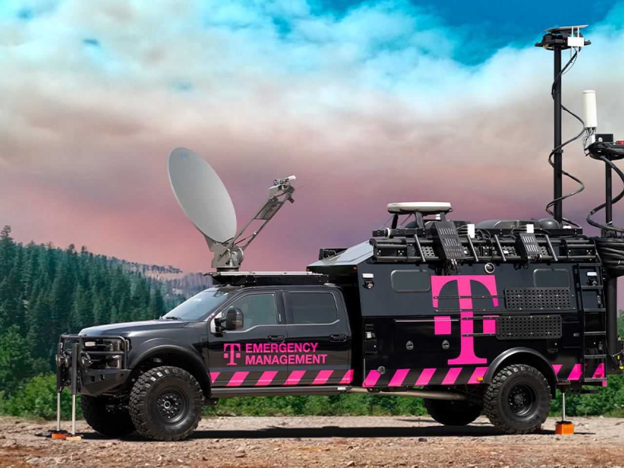 black and pink truck in front of trees and sky