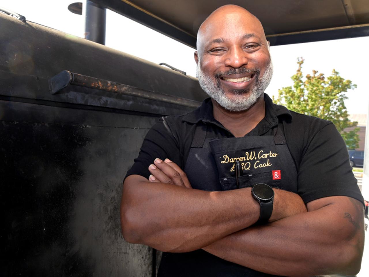 Darren W. Carter with the smoker he uses for his BBQ food truck.