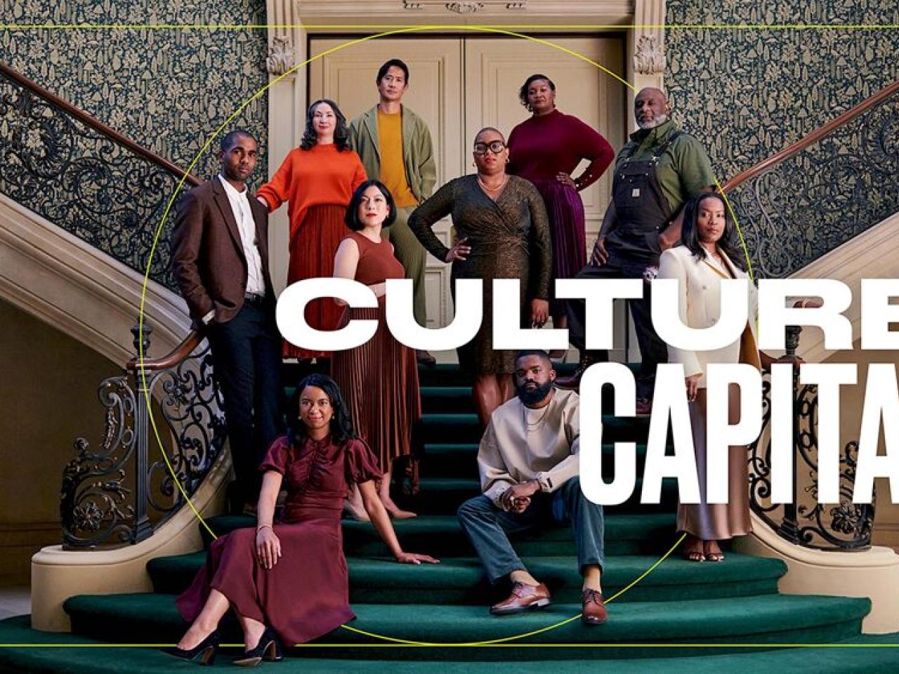 A group of people posed on a large stair case with emerald green carpet and intricate railings "Culture Capital" over the image.