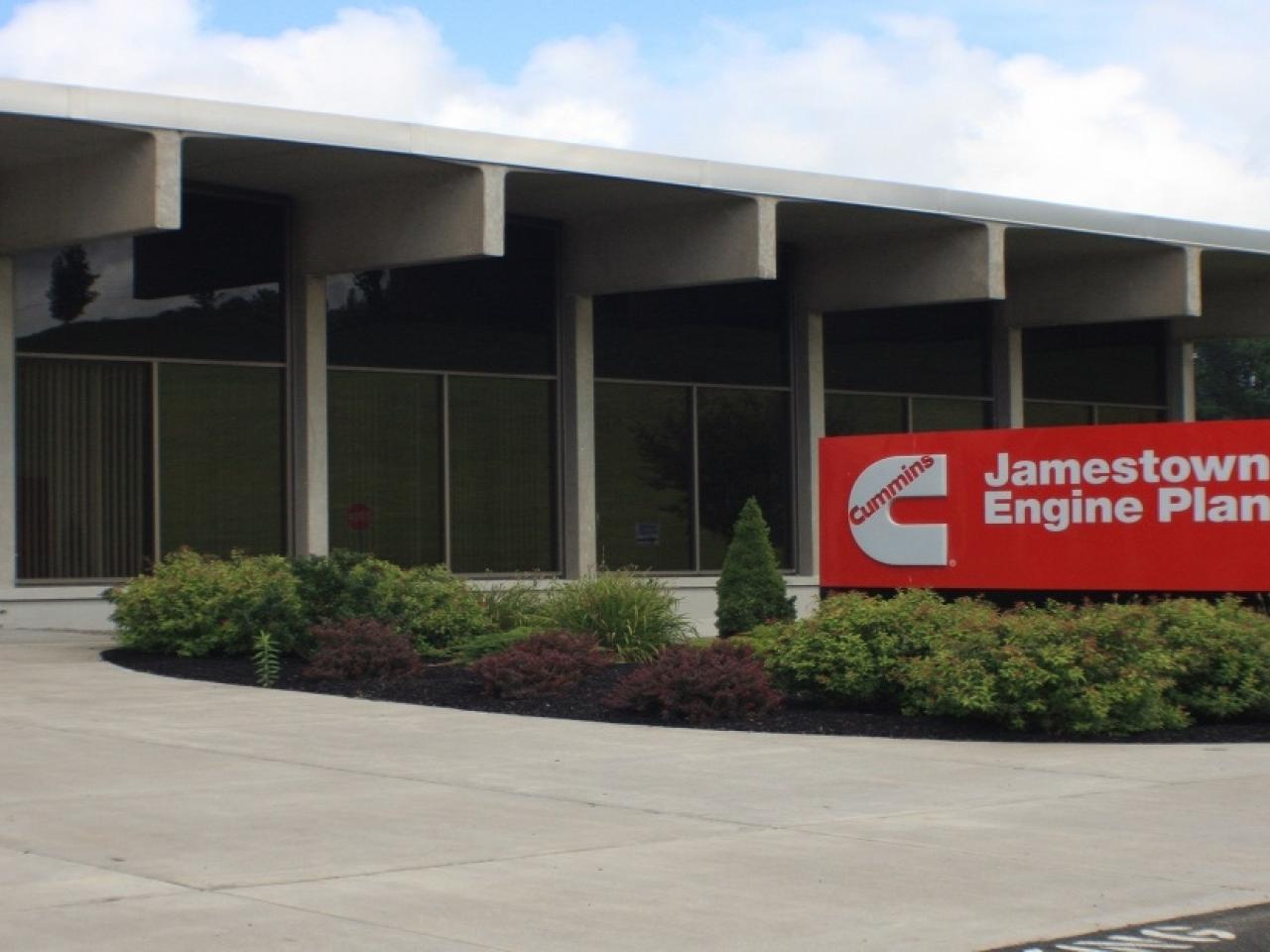 The front of a building with a red and white sign for Jamestown Engine Plant 