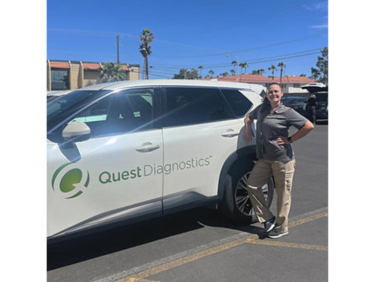 Jamie Croft standing next to a vehicle with Quest Diagnostics logo on the side.