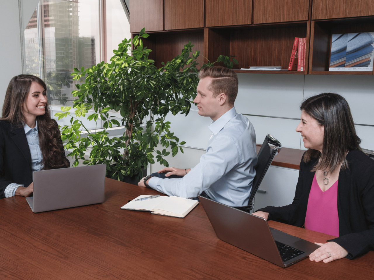 Three Gildan employees sitting around a conference table in an office