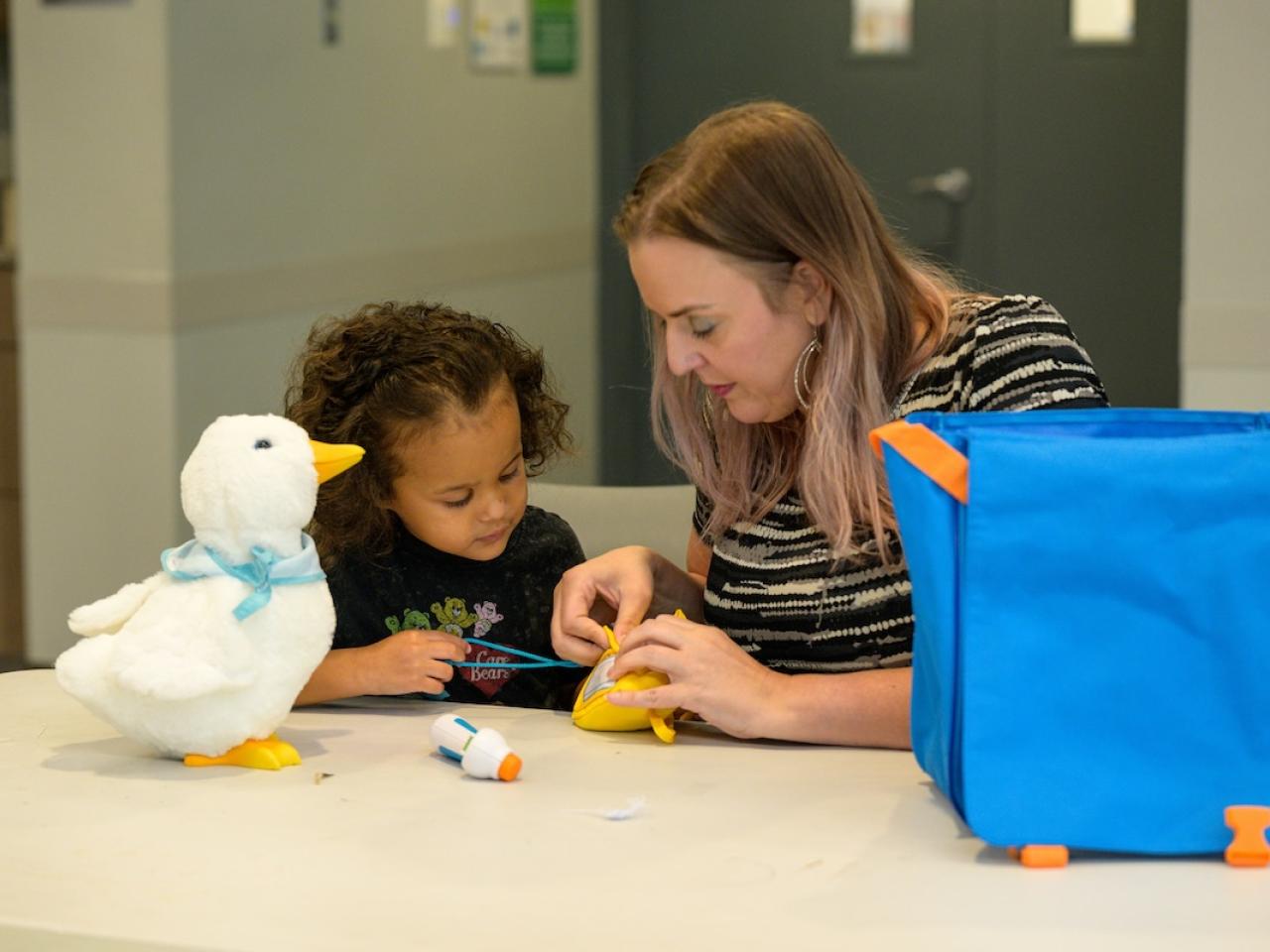 adult with child and stuffed toy duck