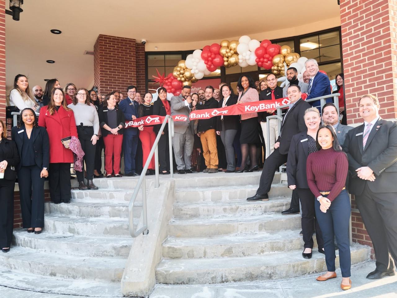 KeyBank Branch Manager Jeffrey Almanzar (center with scissors) cuts the ribbon on the bank’s newest branch at 1 Main Street Port Chester, NY at a ribbon-cutting ceremony held January 29, 2025.