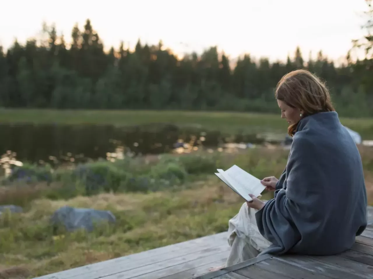 person sitting outside reading a book 