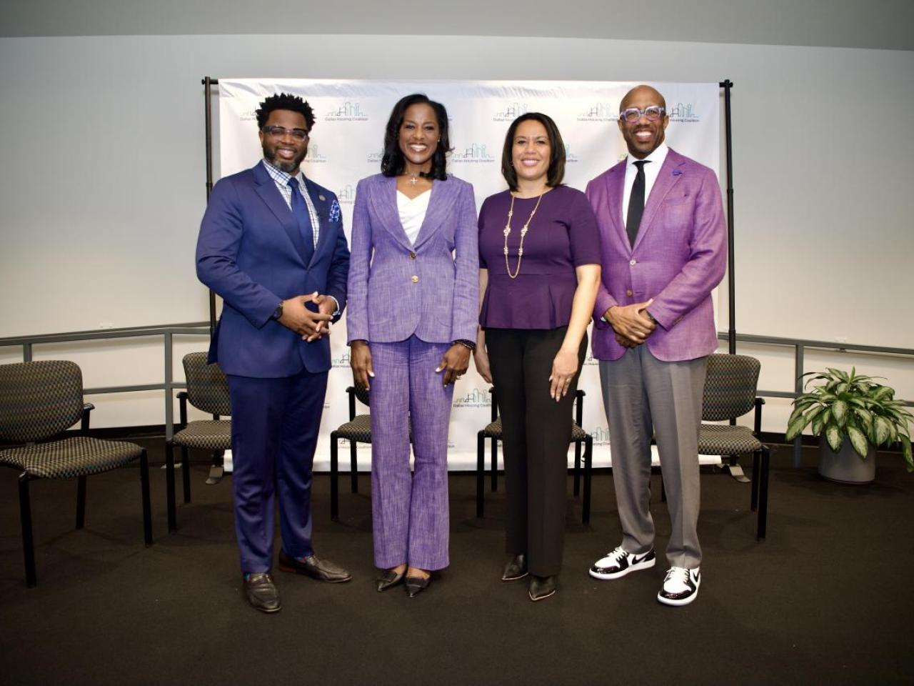 Four people standing in a conference room