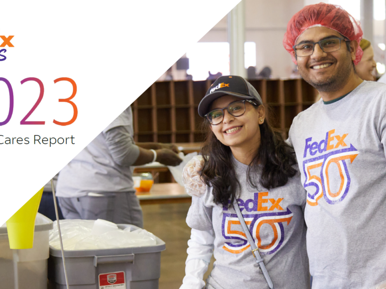 Two smiling people in "FedEx 50" t-shirts. "FedEx Cares 2023" on the side.