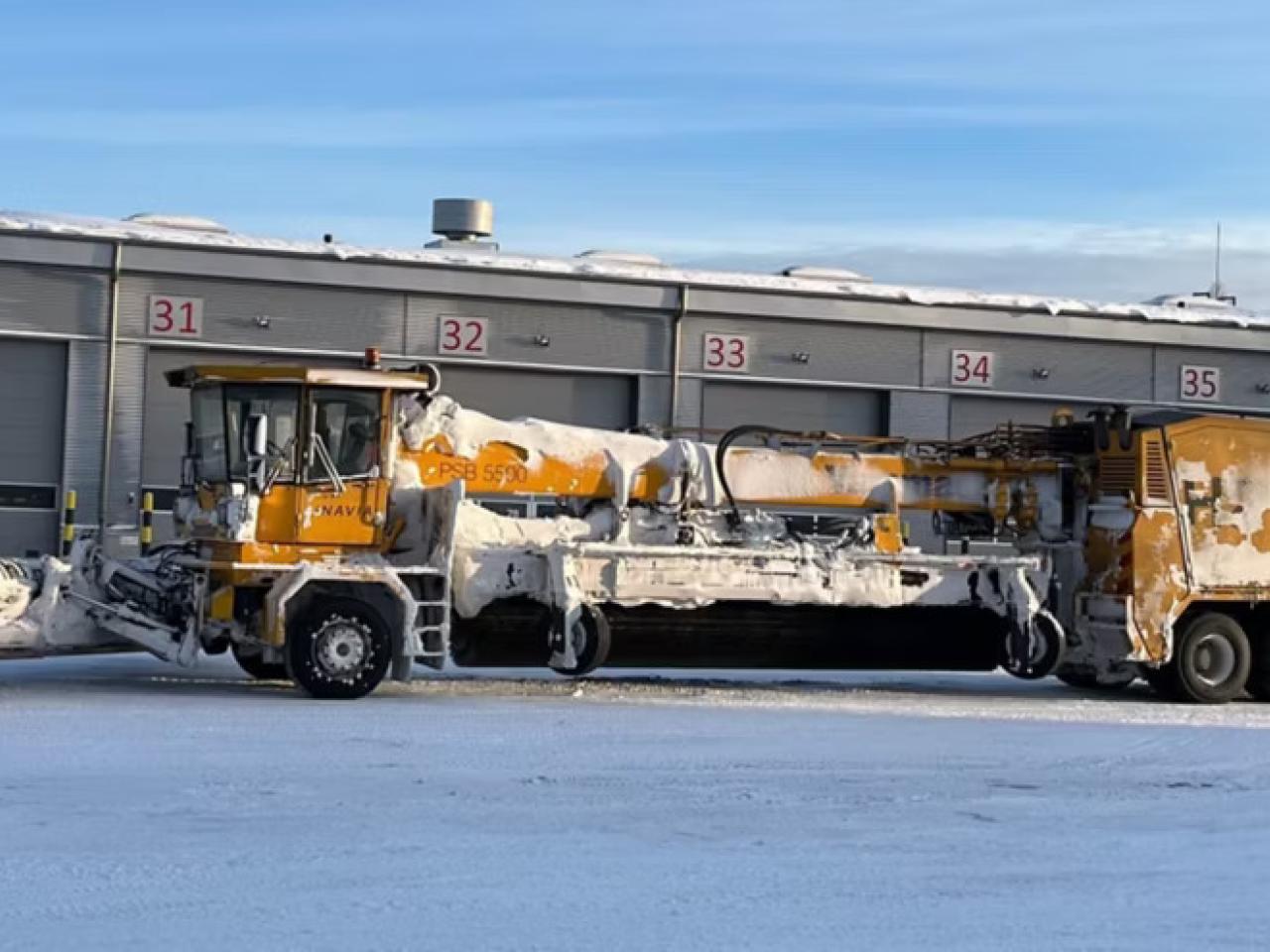 A large de-icing machine outside covered in snow