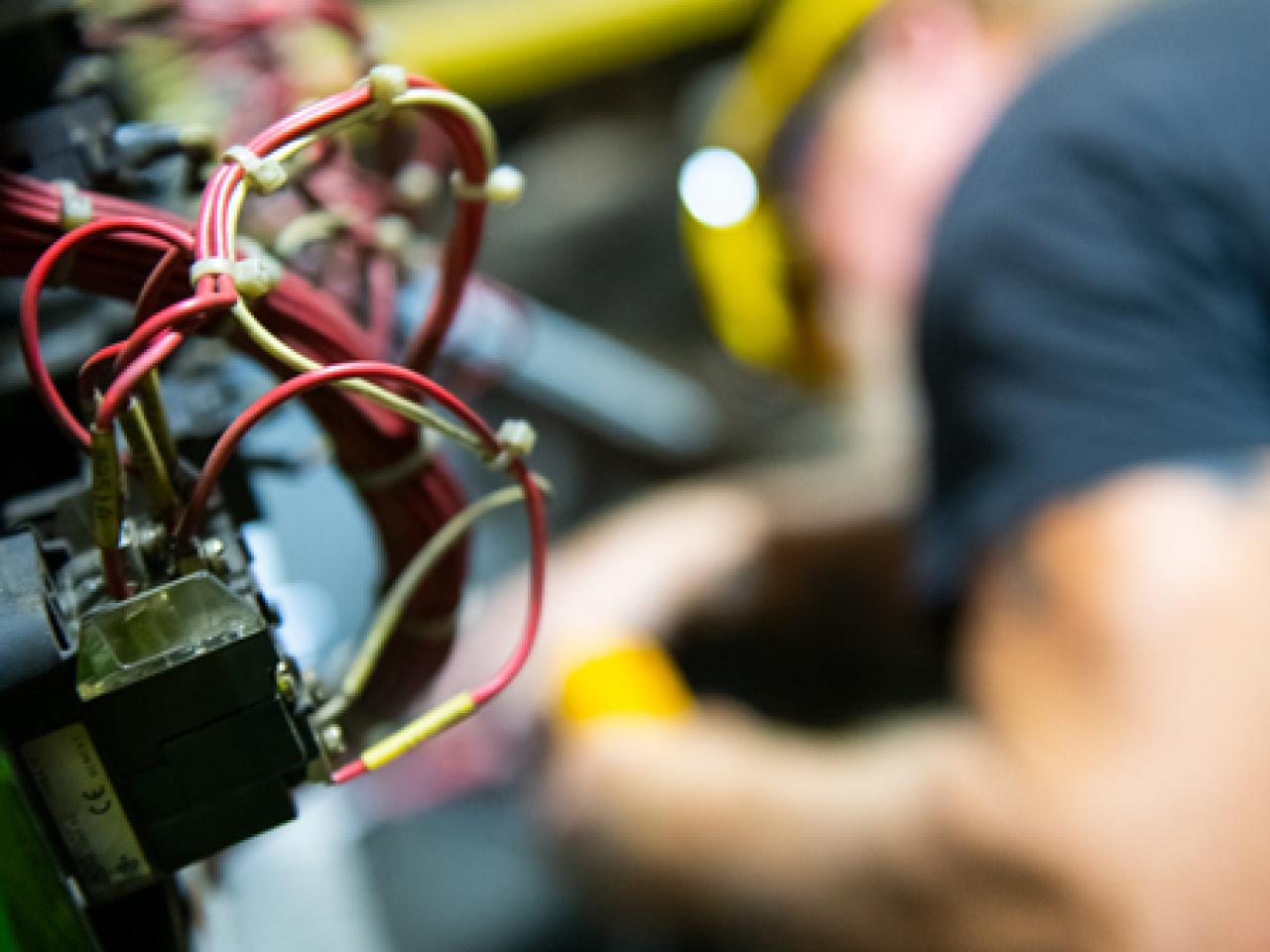 electrician, out of focus, with wiring in the foreground