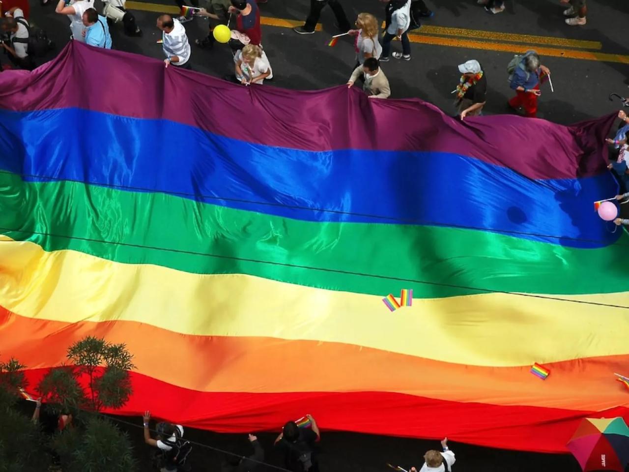 Pride Flag shown from above at a parade.