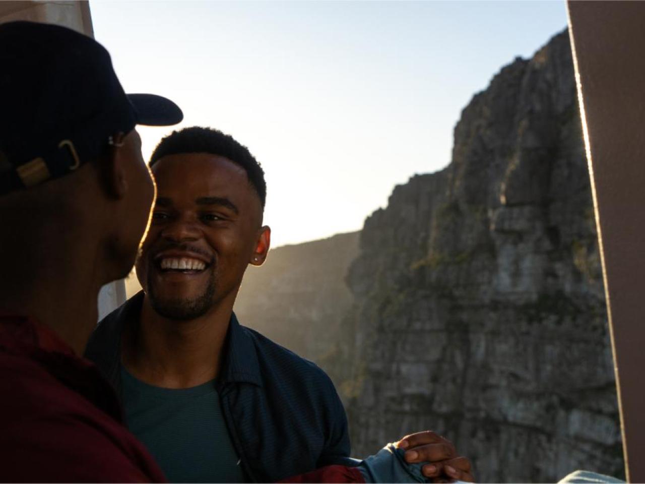 Two people looking at each other. A rocky landscape behind them.