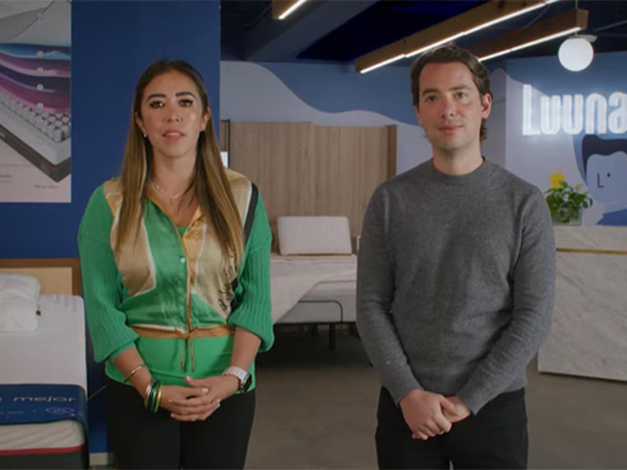 Two people standing in a mattress showroom.