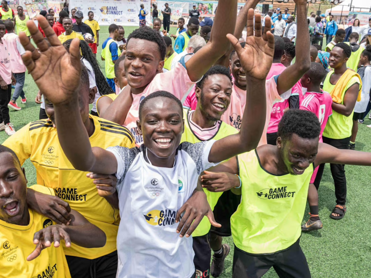 A group of people outside in bright athletic shirts celebrating