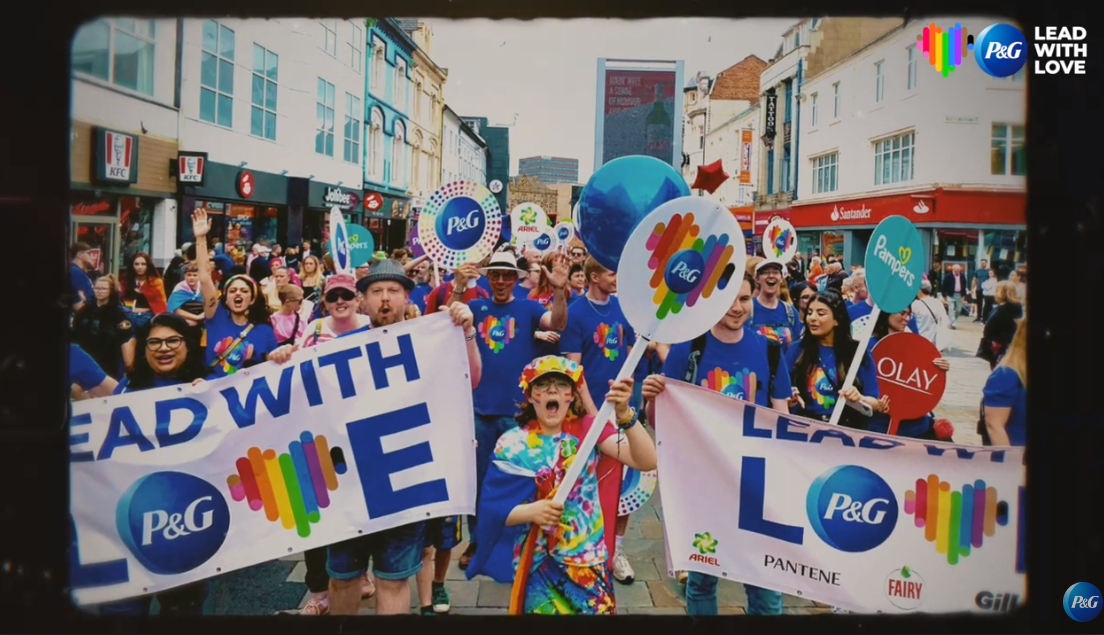 Pride parade with signs "Lead with Love" P&G