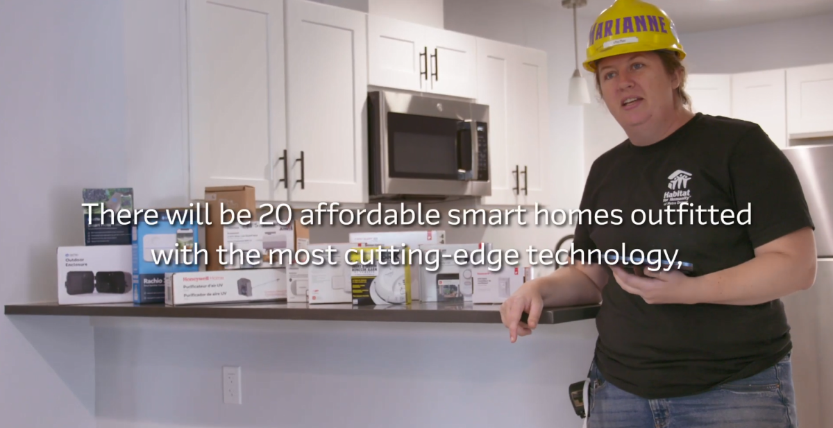 A worker standing next to a kithen island with many different tech products on it.