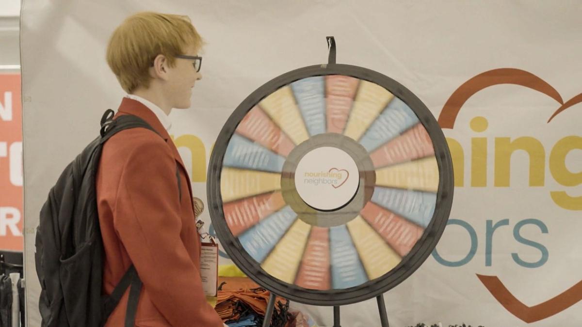 Person standing in front of spinner wheel