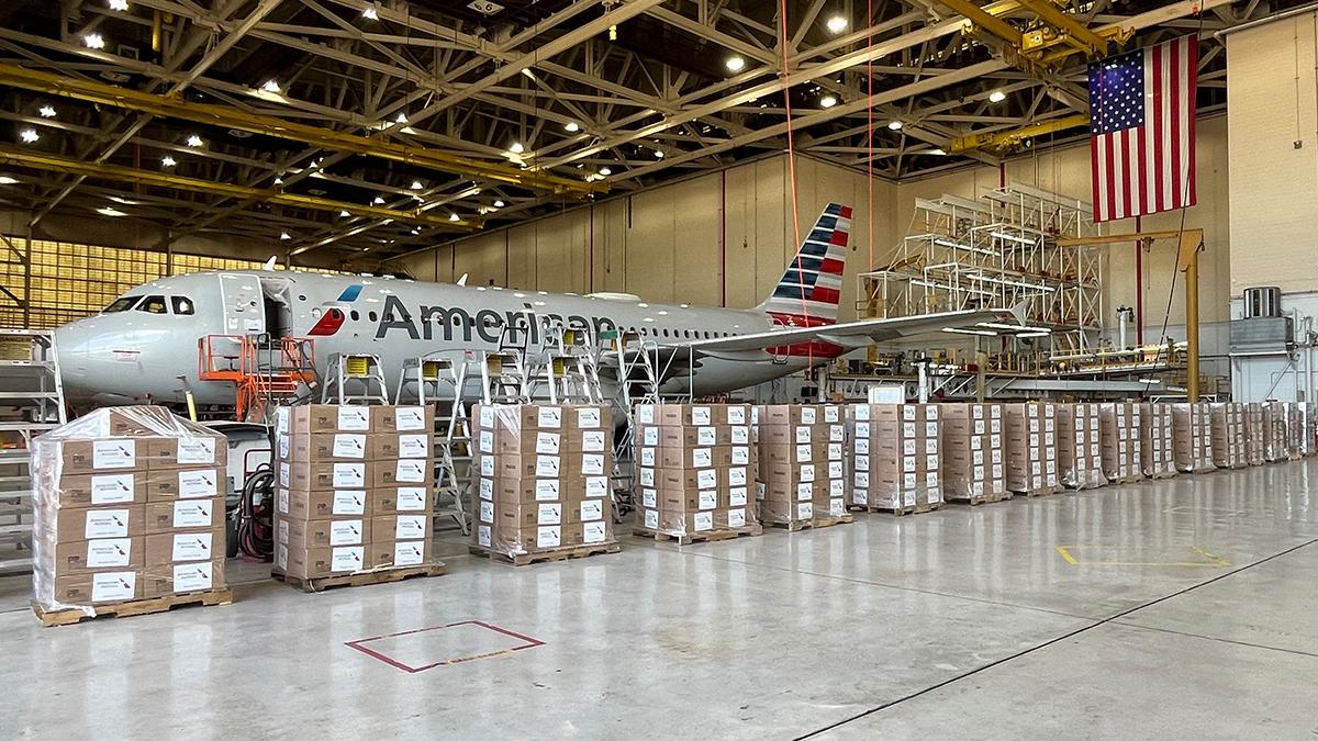 Boxes stacked in front of an American Airlines plane