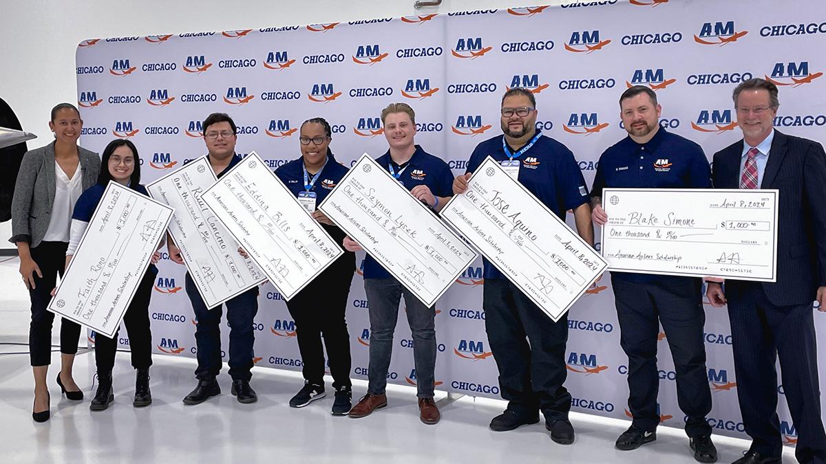 People standing together holding large checks