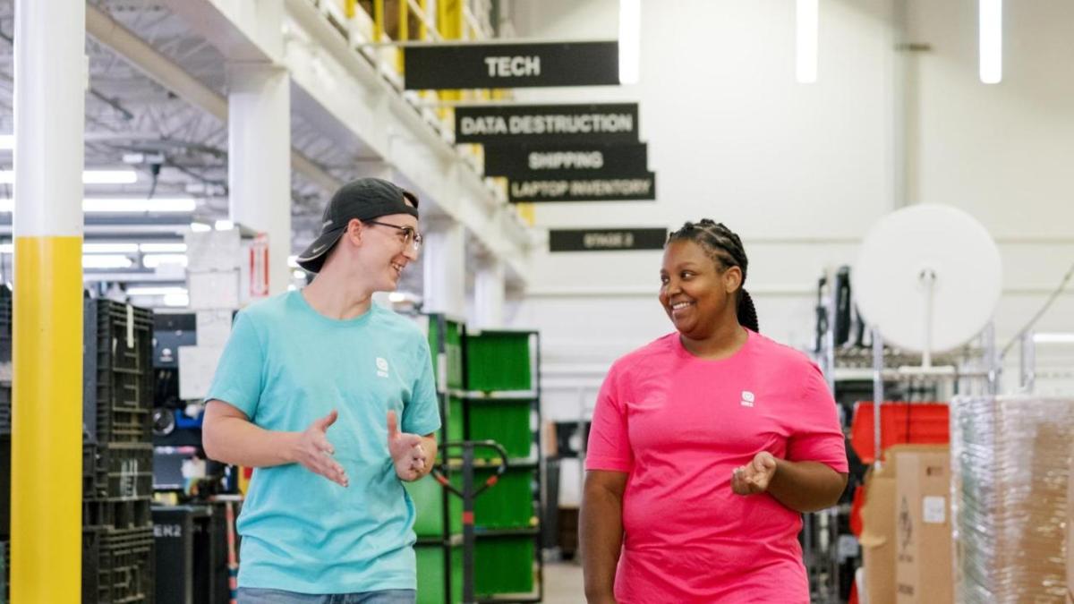 Two smiling people talking and walking inside a building