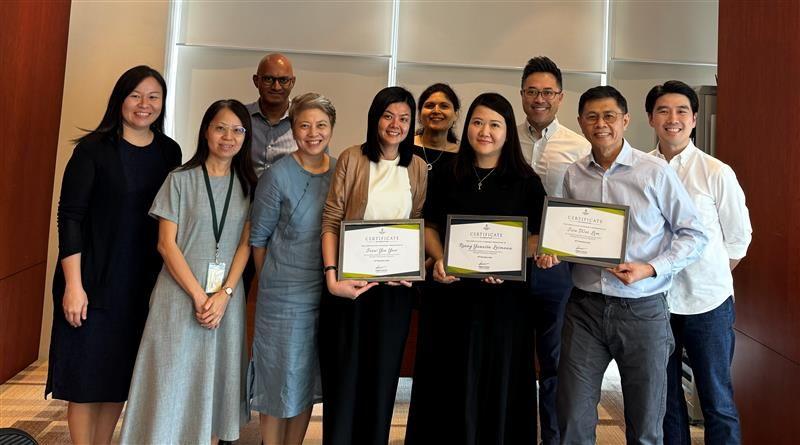 A group of people standing together, holding diplomas