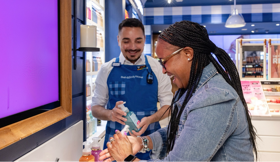 A Bath & Body Works employee helping a customer