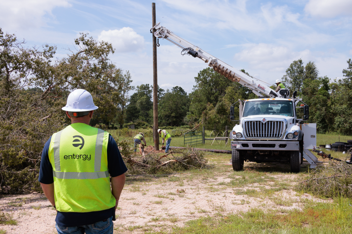 Worker in high-vis vest watching electrical work being done