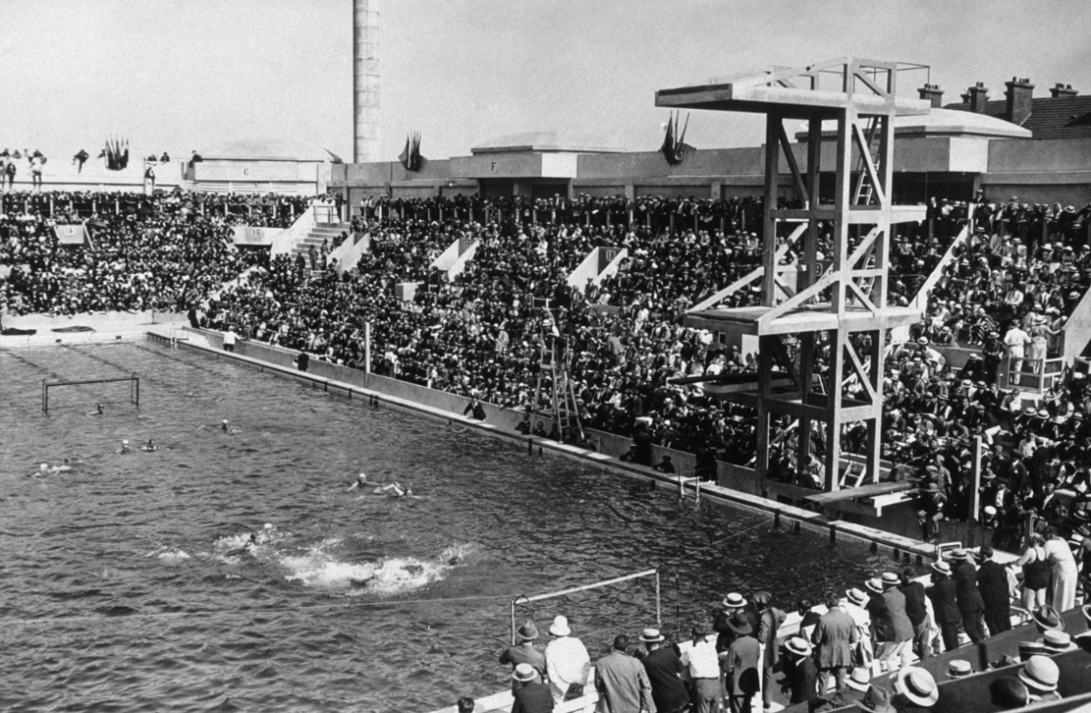 A large swimming pool with swimmers and spectators