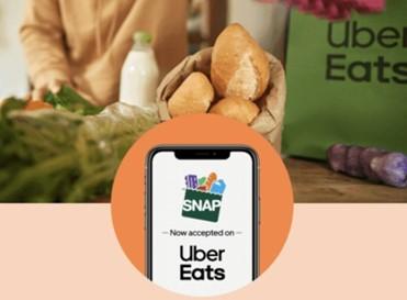 Image of groceries with phone screen that says "SNAP Now accepted on Uber Eats"