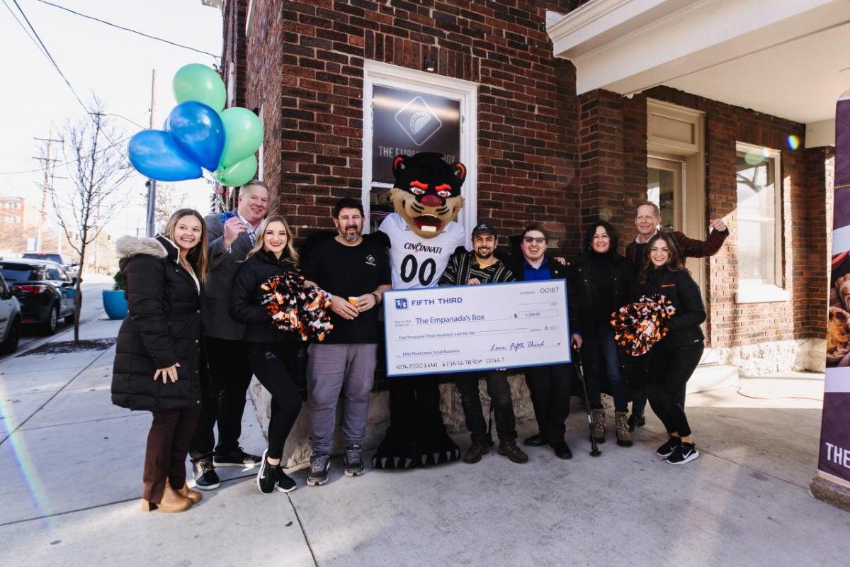 A group of people holding up an oversized check