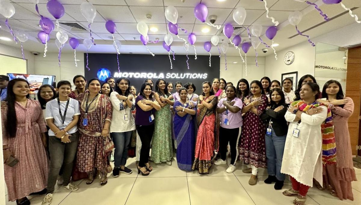 A group posing with balloons above them