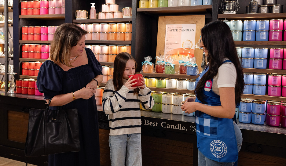 A Bath & Body Works employee helping two customers in a store